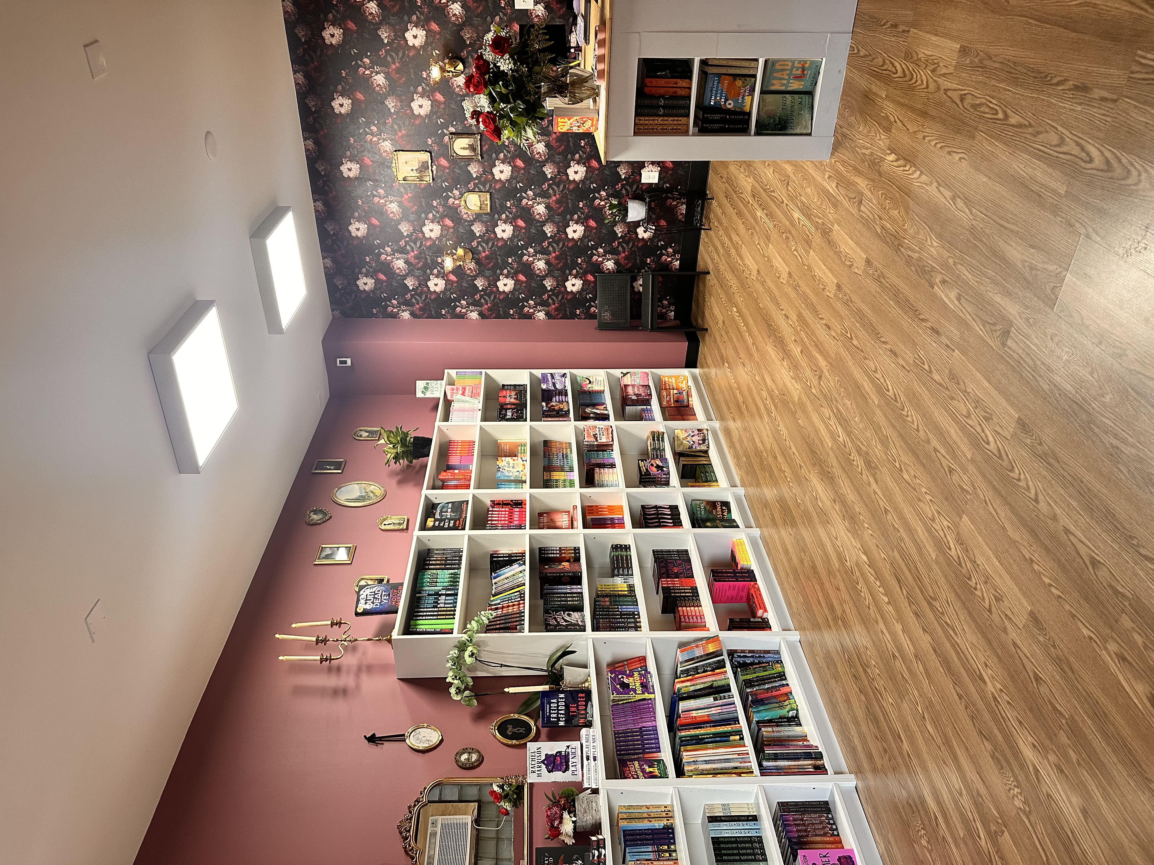 Warm interior of Bound by Books showing curated bookshelves and vintage wallpaper